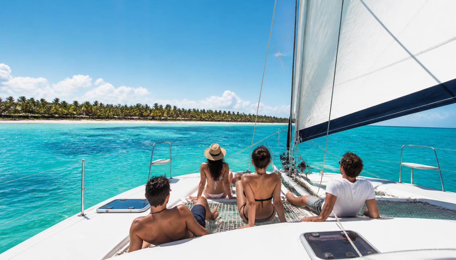 Friends relaxing on a catamaran off the Punta Cana coast in turquoise water